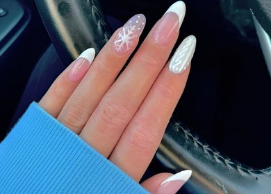 Elegant winter nail art at Lydia’s Nails, Canton, Massachusetts, US. Features snowflake and white patterns.