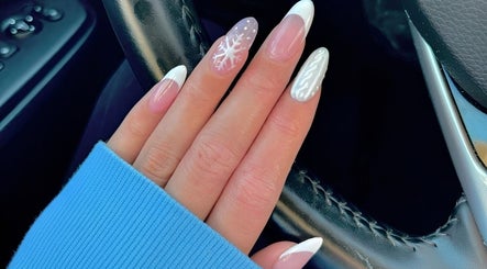 Elegant winter nail art at Lydia’s Nails, Canton, Massachusetts, US. Features snowflake and white patterns.