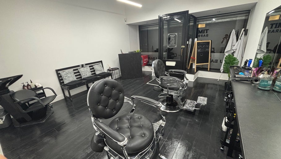 Stylish interior of TIMIJBARBERS in Paisley, Scotland, GB featuring modern black barber chairs.