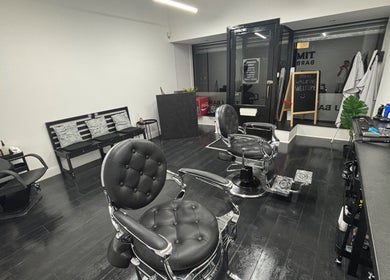 Stylish interior of TIMIJBARBERS in Paisley, Scotland, GB featuring modern black barber chairs.