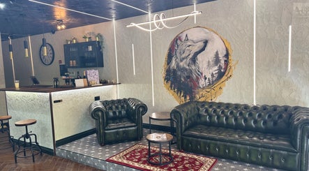 Relax in style at The Wolfs Grooming Lounge Hadley Wood, Barnet, England, GB. Chic sofas and wolf mural ambiance.