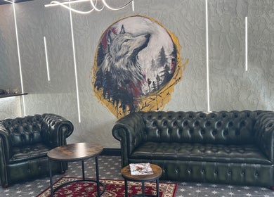Chic interior of The Wolfs Grooming Lounge Hadley Wood, Barnet, England, GB, featuring a wolf mural and leather seating.