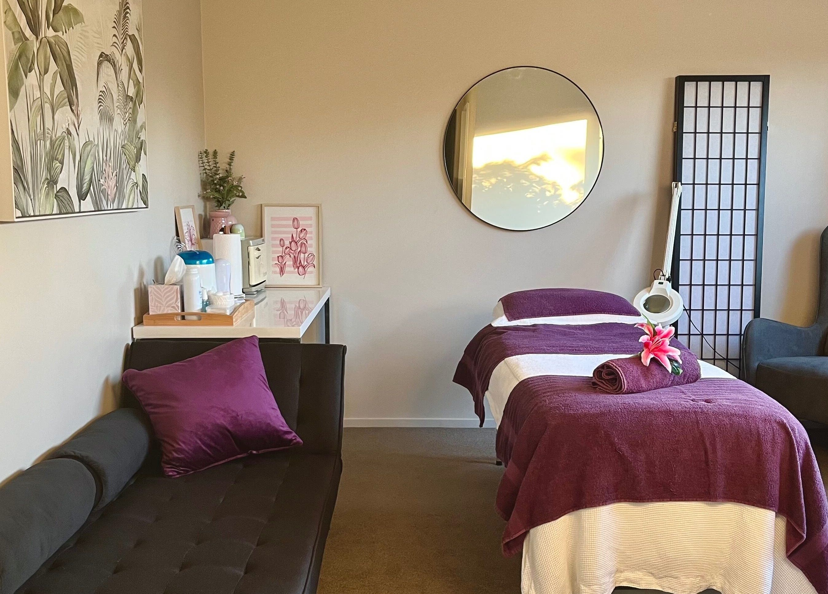 Serene treatment room at Selene Beauty, Christchurch, with plush seating and calming decor for wellness.