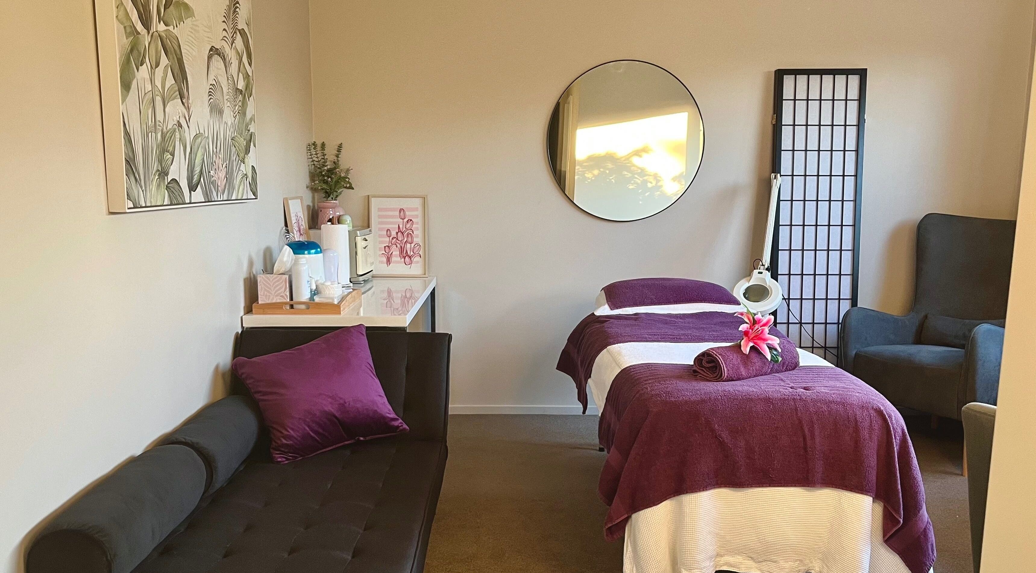 Serene treatment room at Selene Beauty, Christchurch, with plush seating and calming decor for wellness.