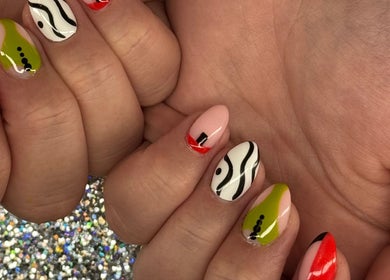 Vibrant nail art at SCULPTED BY LIZA, Bowling Green, Ohio, US, showcasing unique designs in red, green, and black.