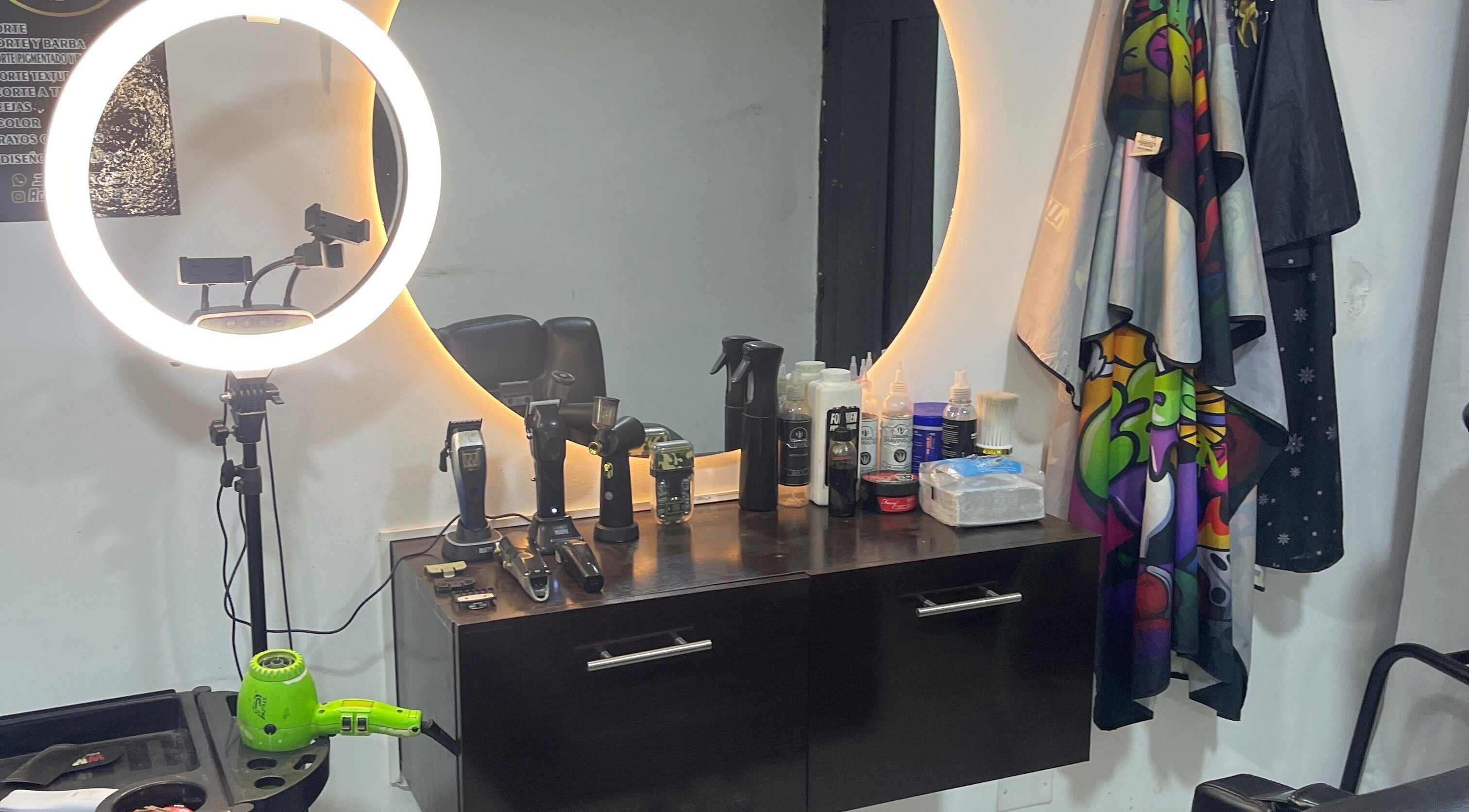 Estación de trabajo en Aguilar barber shop, Cali, Valle Del Cauca, CO con herramientas y espejo iluminado.