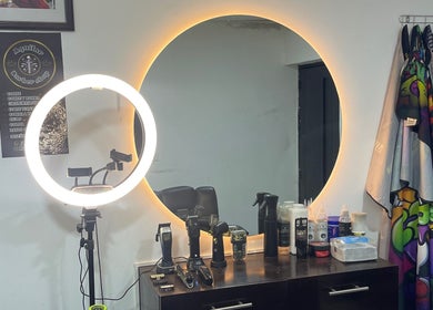 Estación moderna en Aguilar barber shop, Cali, Valle Del Cauca, CO, con espejo redondo iluminado.