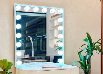 Stylish vanity area at HighBrow | The Adelphi, Singapore, Singapore, SG with illuminated mirror and plants.