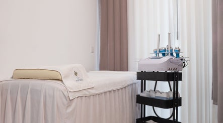 Elegant treatment room at Sage Oasis Beauty Studio in Singapore, SG with modern equipment and a plush massage table.