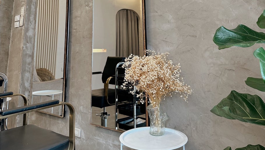 Elegant salon corner at Gorjosh By Joshua Yu, Cagayan De Oro City, featuring a mirror, chair, and flowers.