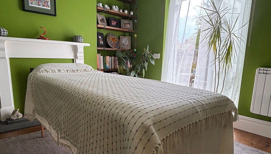 Relaxing treatment room at Better Health Kinesiology, Cardiff, Wales, GB, with green walls and a cozy bed.