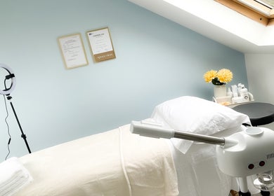 Relaxing treatment room at Soleil Skin Studio, Port Tennant, Wales, GB with calming decor and fresh flowers.