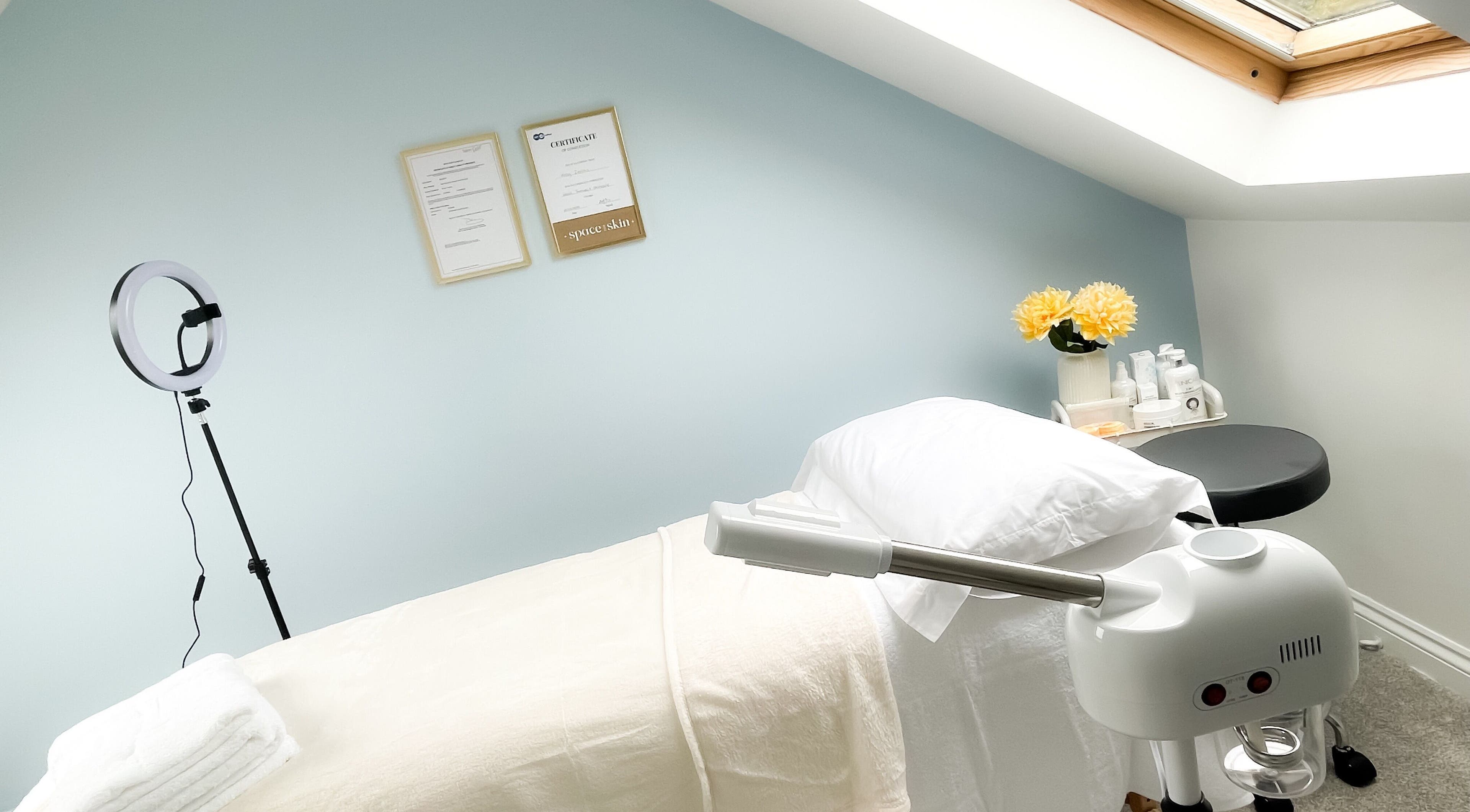 Relaxing treatment room at Soleil Skin Studio, Port Tennant, Wales, GB with calming decor and fresh flowers.