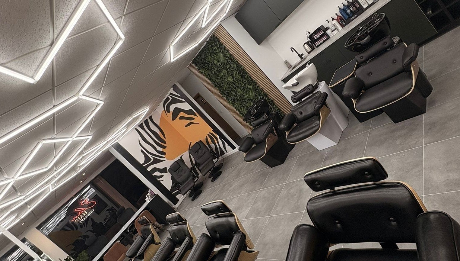 Interior moderno do Élan hair concept em Leiria, Leiria, PT com cadeiras confortáveis e design estiloso.