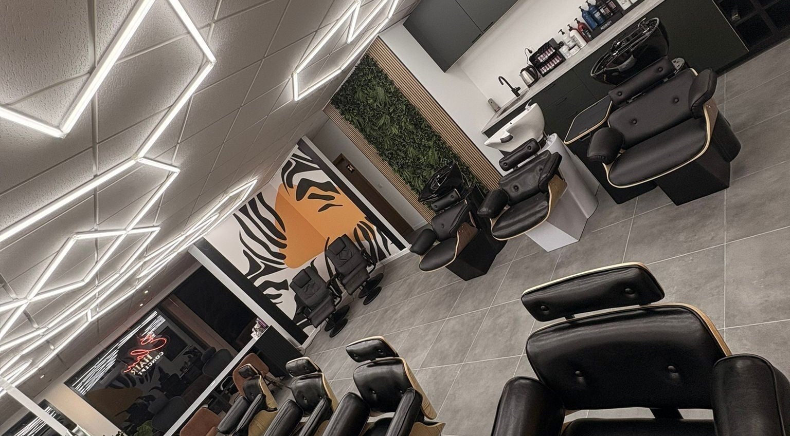 Interior moderno do Élan hair concept em Leiria, Leiria, PT com cadeiras confortáveis e design estiloso.