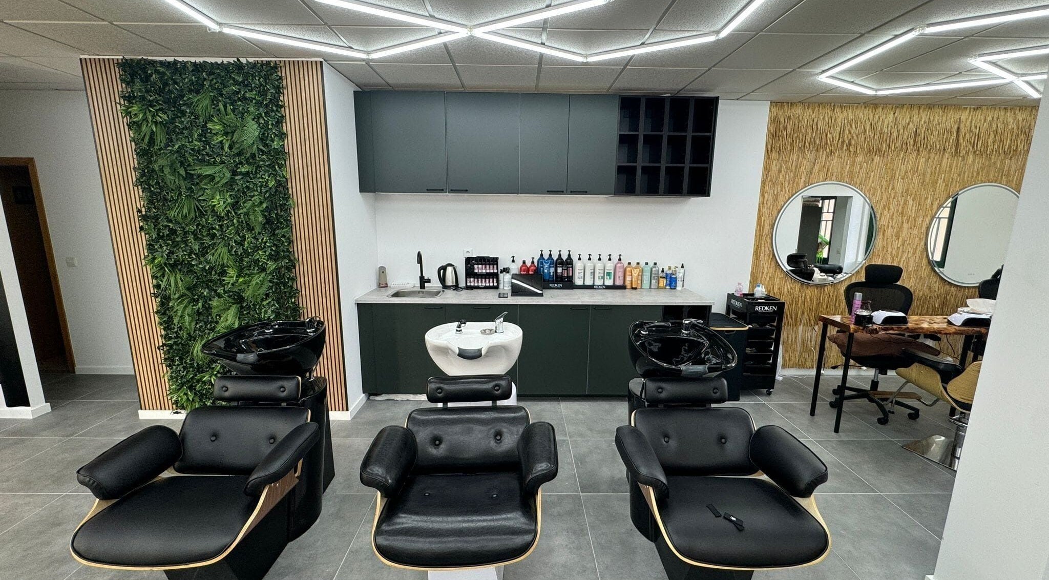 Interior moderno do Élan Hair Concept, Leiria, Leiria, PT, com cadeiras confortáveis e design verde vibrante.