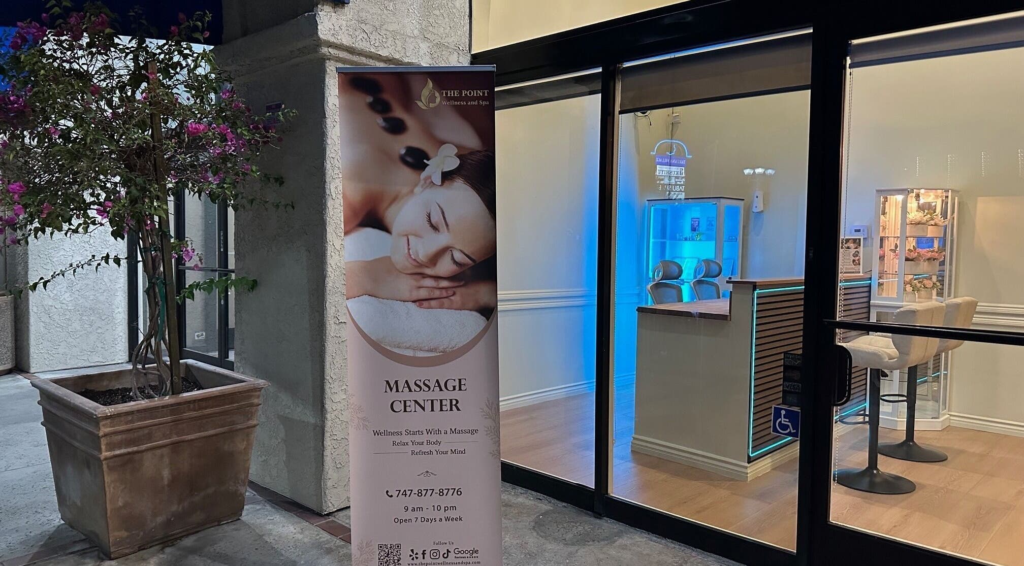 Entrance of The Point Wellness and Spa in Tarzana, California, US with a massage banner and cozy interior.