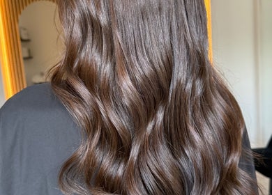 Shiny, wavy brown hair styled at TJJ_Hair Crawley, England, GB in a luxurious salon setting.