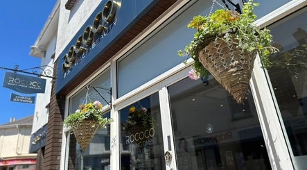 Front entrance of NailsByMaria in Torquay, England, GB, with hanging plants and a bright exterior.