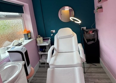Cozy treatment room at DMD Aesthetics, Eccles, England, GB with a modern white chair and ambient lighting.