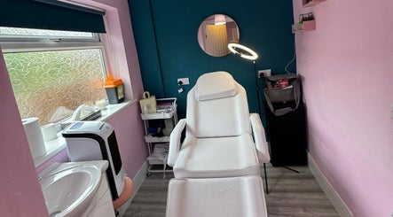 Cozy treatment room at DMD Aesthetics, Eccles, England, GB with a modern white chair and ambient lighting.