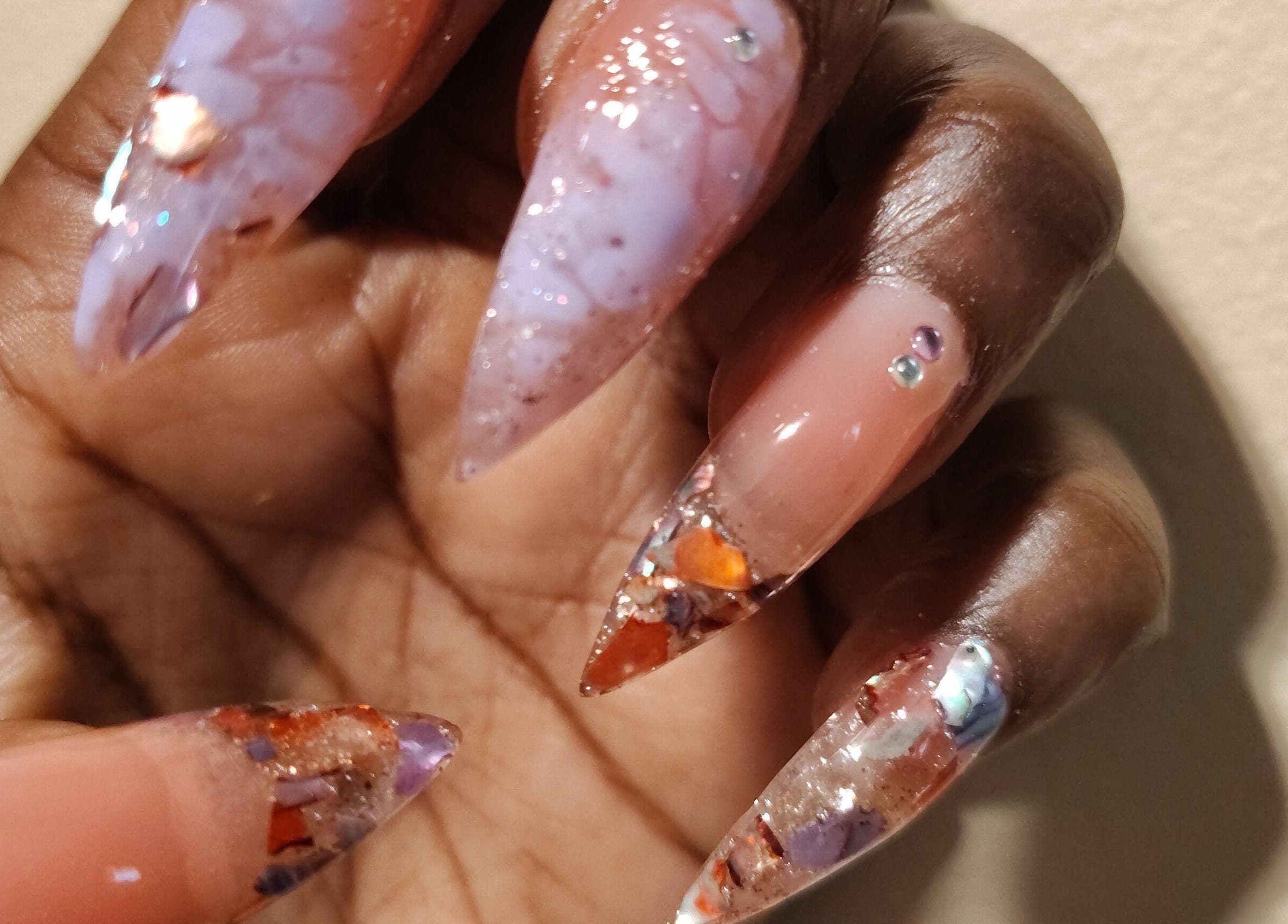 Intricate nail art design at QueenCo Nails, Bartlett, Tennessee, US showcasing elegant, multi-colored patterns.