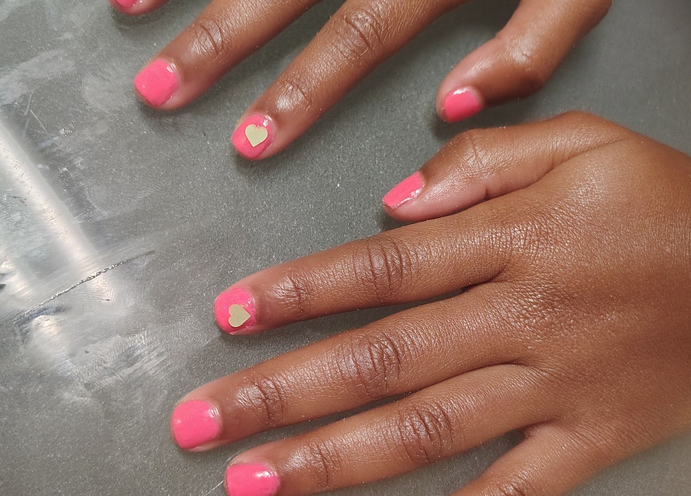 Pink nails with heart design at QueenCo Nails, Bartlett, Tennessee, US for stylish nail art.