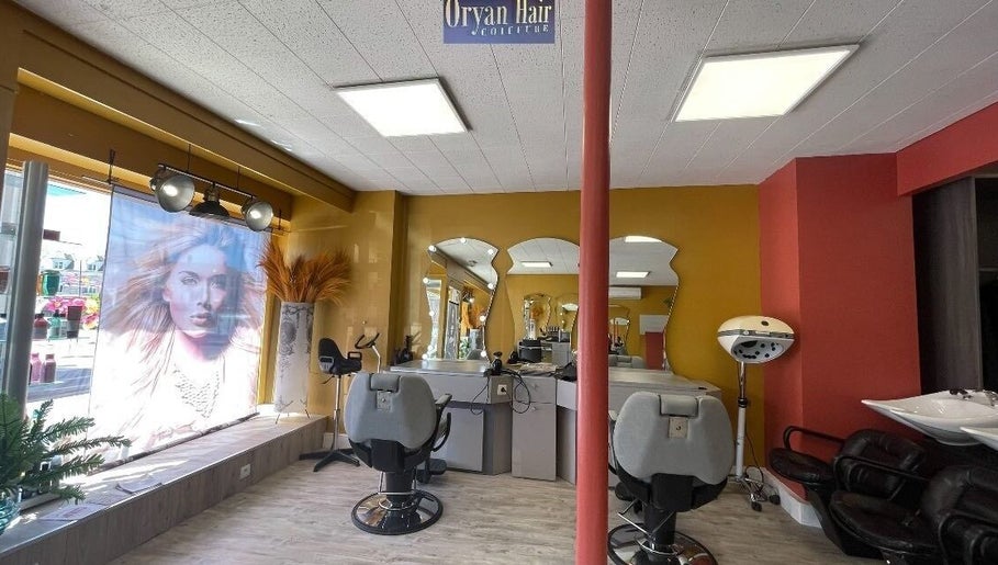 Intérieur de Oryan Hair à La Loupe, Centre-val De Loire, FR, montrant fauteuils de coiffure et miroirs élégants.