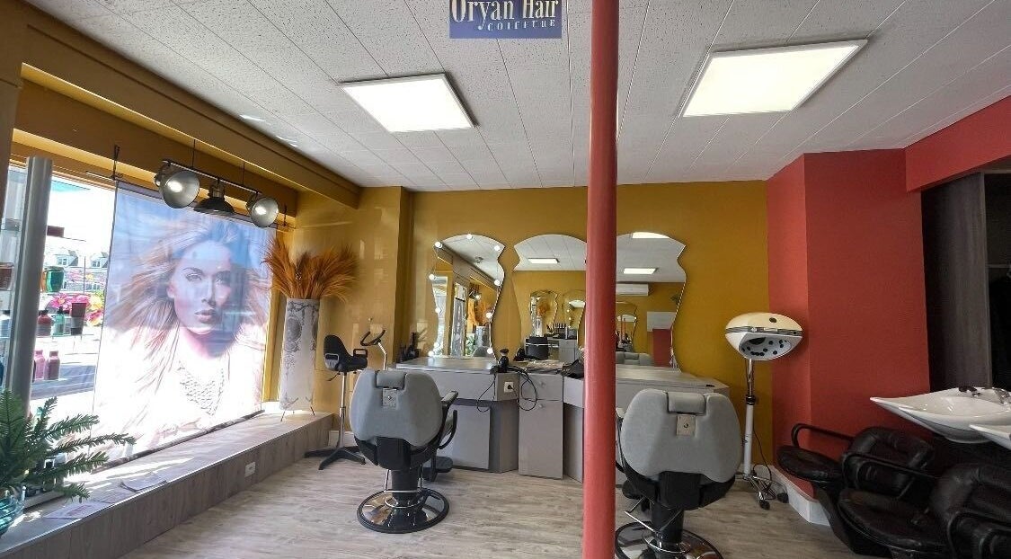 Intérieur de Oryan Hair à La Loupe, Centre-val De Loire, FR, montrant fauteuils de coiffure et miroirs élégants.