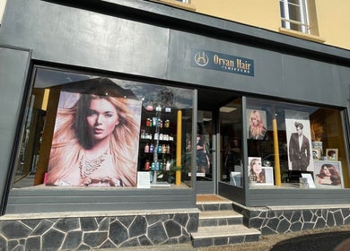 Vitrine élégante du salon Oryan Hair à La Loupe, Centre-val De Loire, FR, mettant en avant des produits et coiffures tendance.