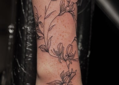 Detailed floral tattoo design at Slyther INK, showcasing arm artistry in Spokane, Washington, US.