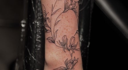 Detailed floral tattoo design at Slyther INK, showcasing arm artistry in Spokane, Washington, US.
