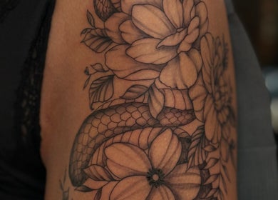 Intricate snake and flower tattoo at Slyther INK in Spokane, Washington, US, showcasing expert artistry.