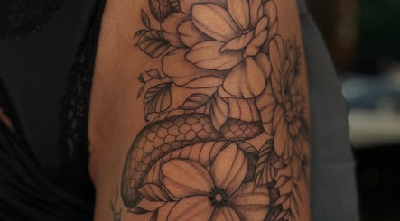 Intricate snake and flower tattoo at Slyther INK in Spokane, Washington, US, showcasing expert artistry.