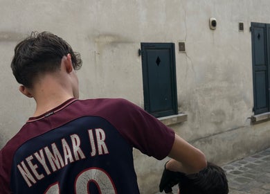 Coiffure extérieure à M2gcut, Paris, Île-de-France, FR, montrant un jeune homme avec un maillot Neymar.