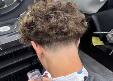 Coiffure dégradée moderne chez M2gcut à Paris, Île-de-France, FR, mettant en valeur des boucles élégantes.