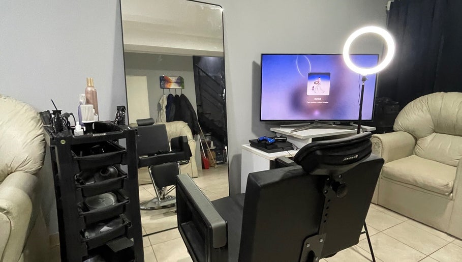Interior del salón Esteban Sandoval HairStyle en Neuquen, Ciudad de Neuquén, AR, con silla y espejo moderno.