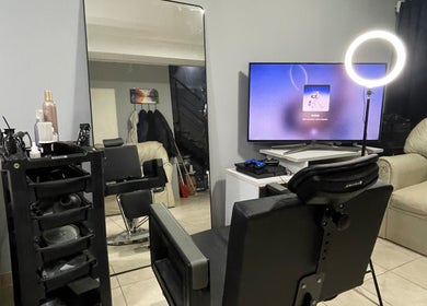 Interior del salón Esteban Sandoval HairStyle en Neuquen, Ciudad de Neuquén, AR, con silla y espejo moderno.