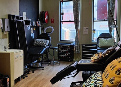Interior of Kaya Garden Tattoo Haymarket, NSW, AU, showcasing a cozy tattoo studio with seating and decor.