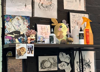 Artistic shelf with tattoo designs and decor at Kaya Garden Tattoo Haymarket, Haymarket, NSW, AU.