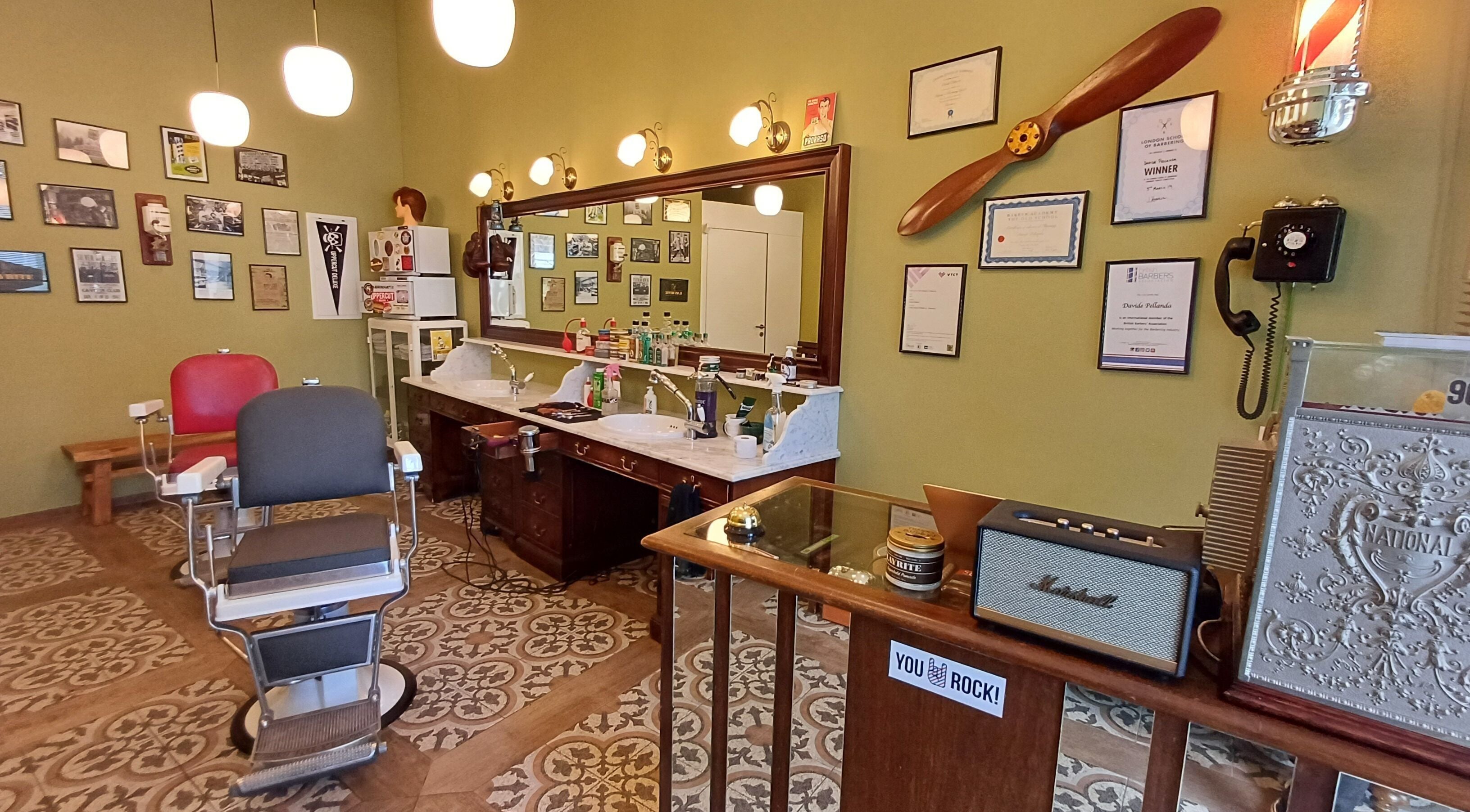Interno vintage di Buddies Barbershop a Losone, Ticino, CH con sedie da barbiere e specchi eleganti.
