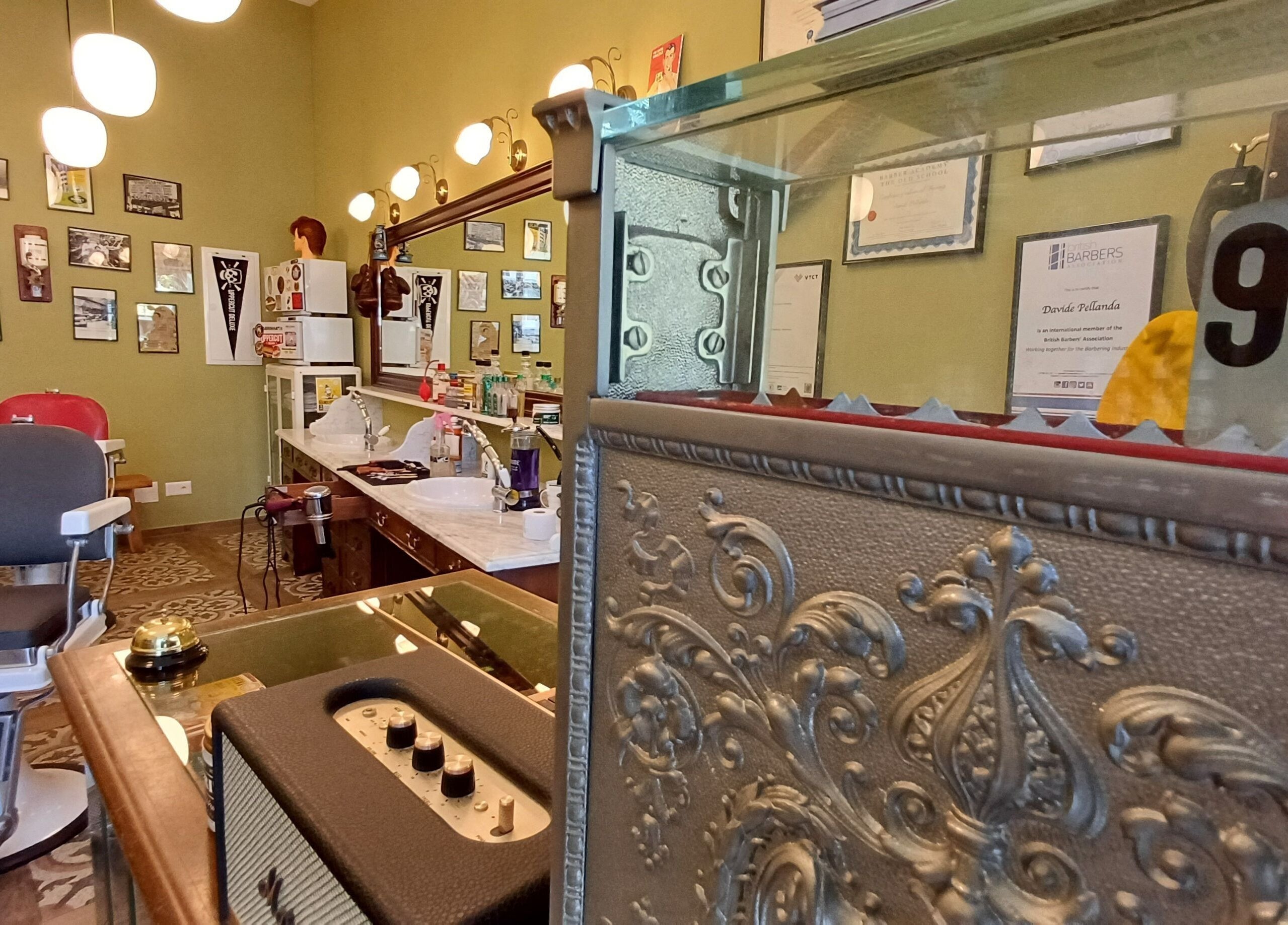 Interno di Buddies Barbershop a Losone, Ticino, CH, stile vintage con sedie da barbiere classiche.