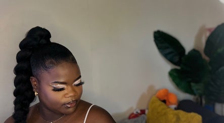 Elegant woman with braided hairstyle at Allure Beaute’, St. Johns, AG showcasing bold, glamorous makeup.