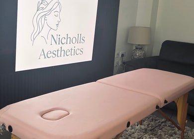 Cozy treatment room at Nicholls Aesthetics in Burton-on-trent, England, GB featuring a pink massage table.