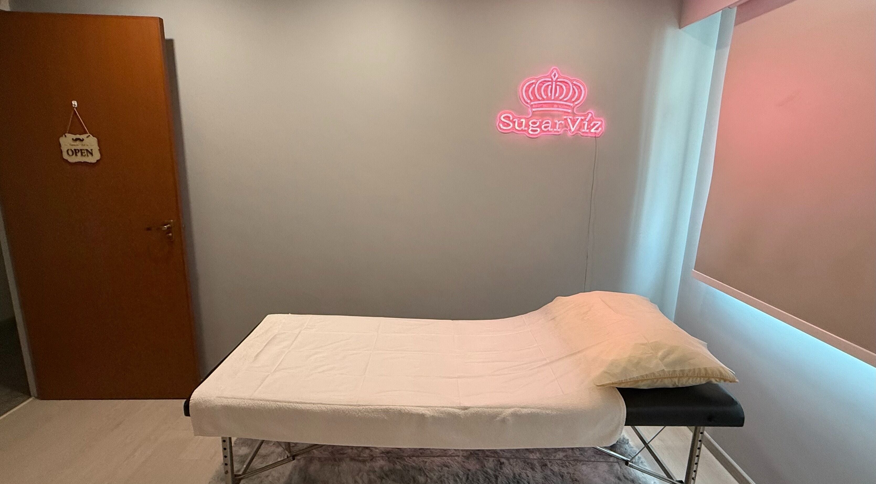 Calm treatment room at SugarViz with a bed, Singapore, Singapore, SG for wellness services.
