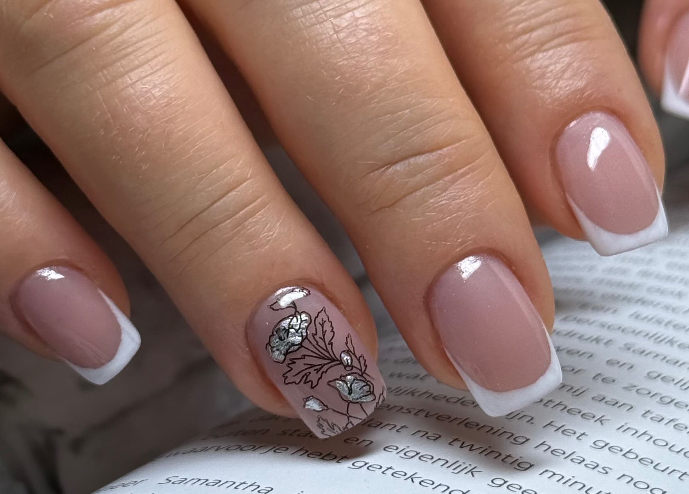Elegant French manicure with floral art at Daria Art & Grace Nail Studio, Eindhoven, Noord-brabant, NL.