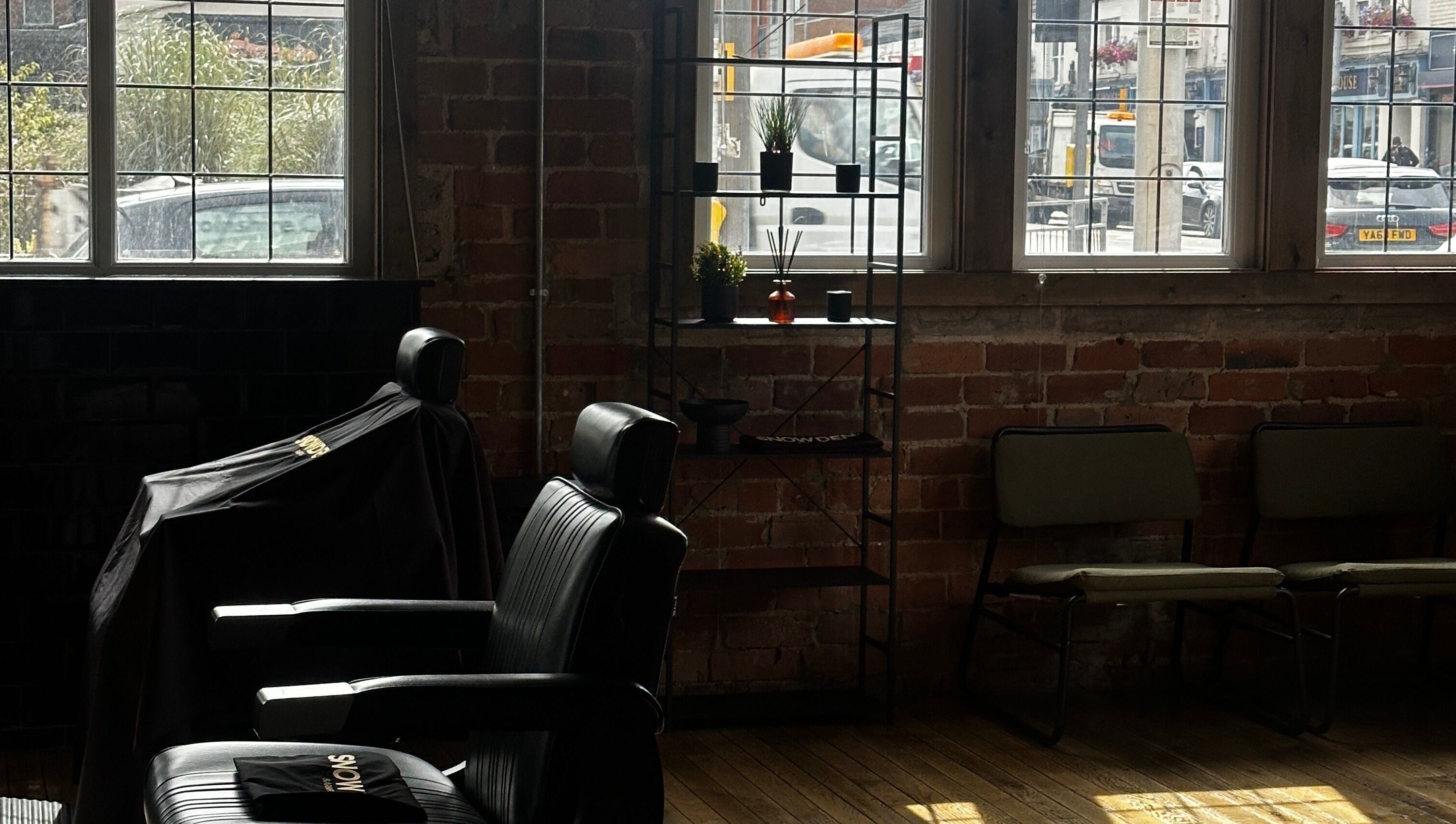 Cozy interior of Snowden Barbers in Scunthorpe, England, GB with vintage chairs and rustic decor.