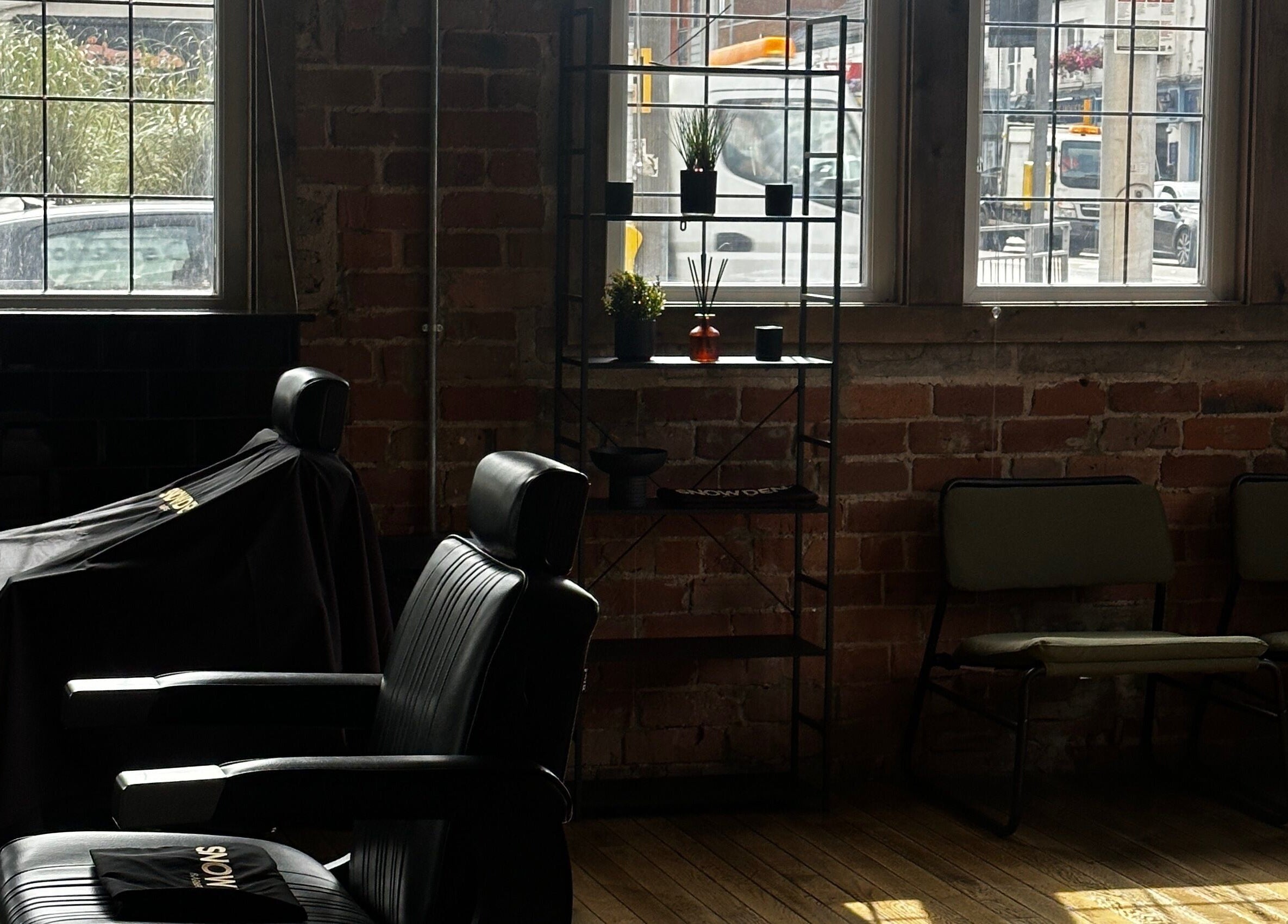 Cozy interior of Snowden Barbers in Scunthorpe, England, GB with vintage chairs and rustic decor.