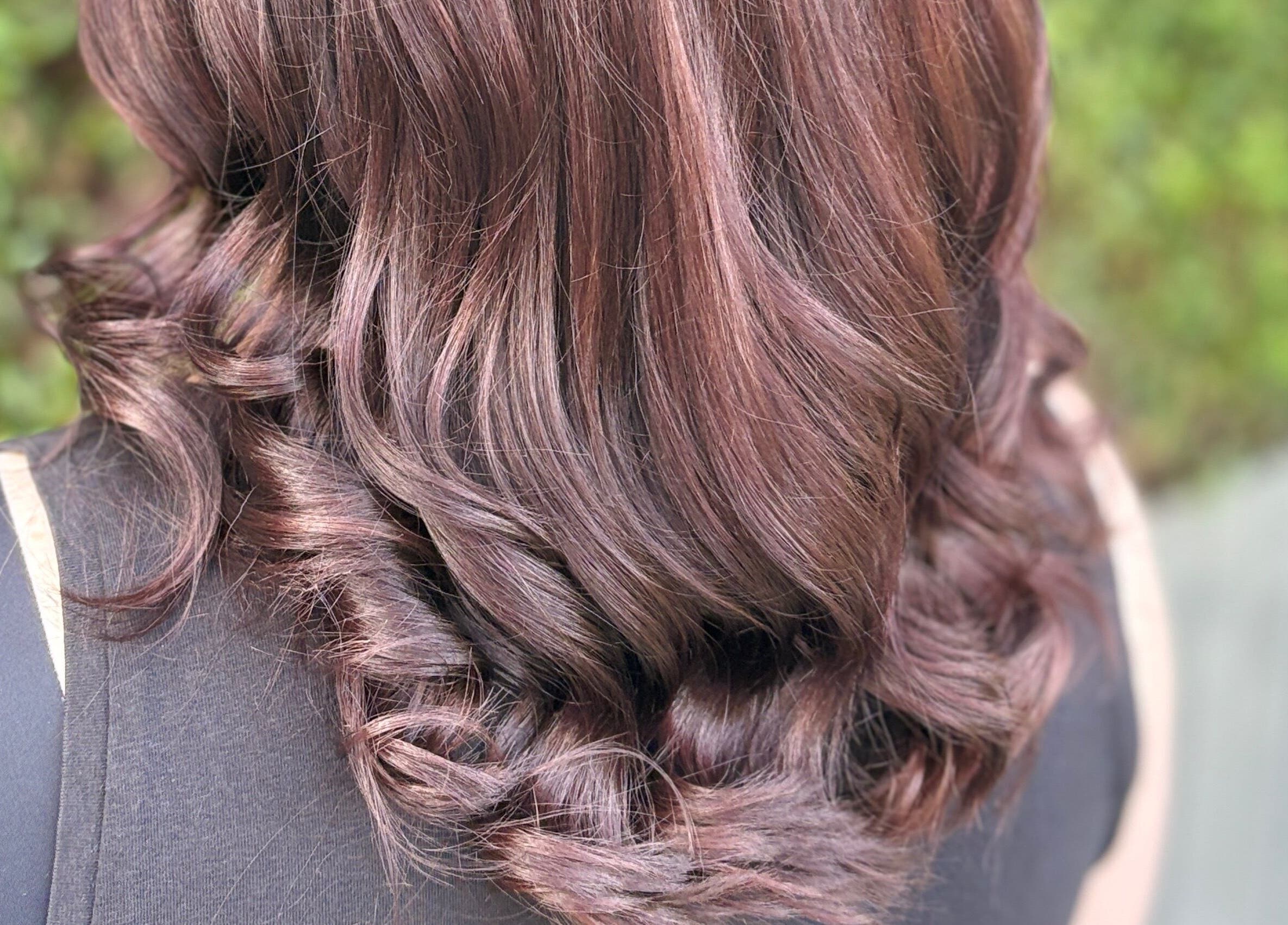 Elegant curled hairstyle at House of Moira Rose, Thirsk, England, GB, showcasing vibrant, shiny brunette hair.