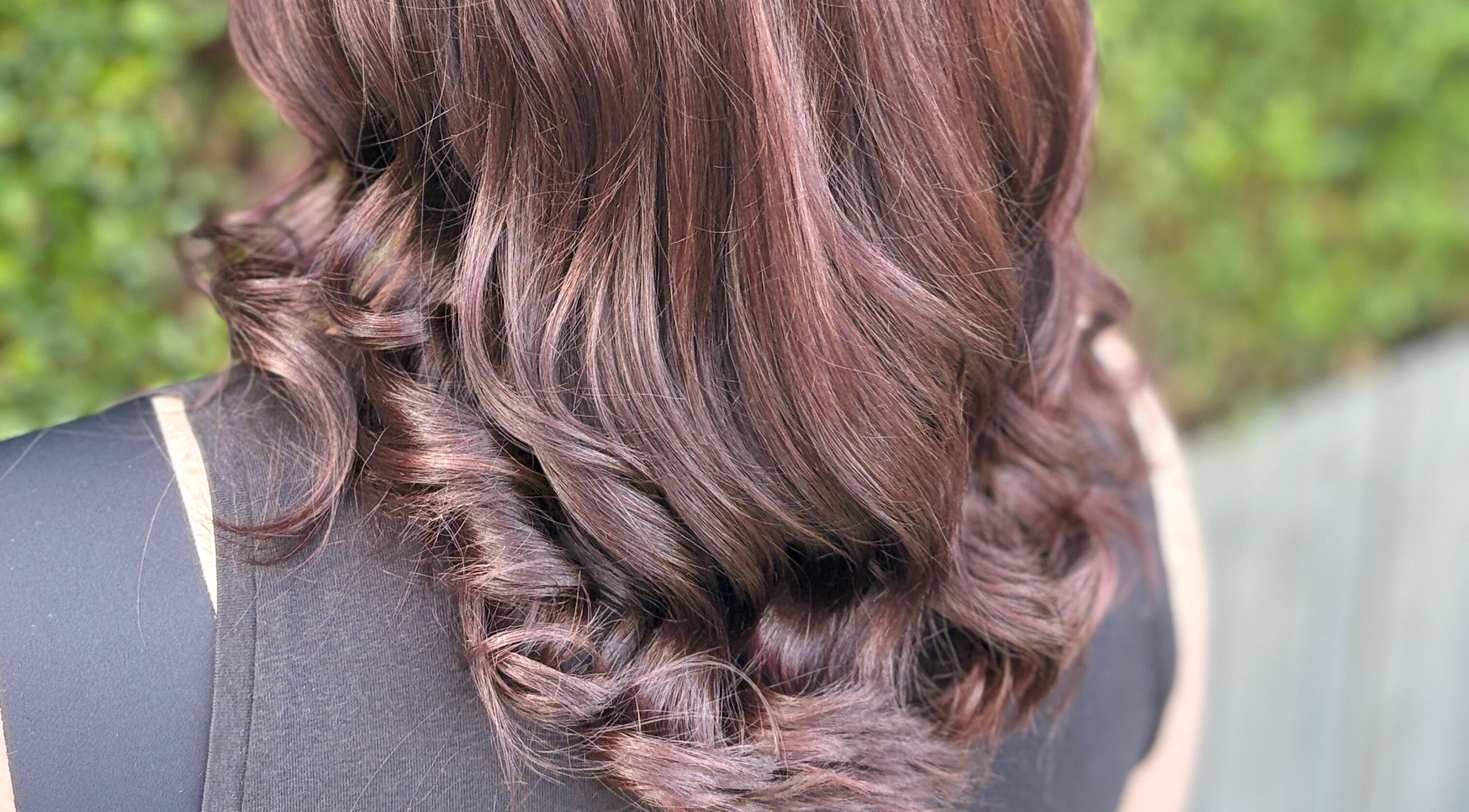 Elegant curled hairstyle at House of Moira Rose, Thirsk, England, GB, showcasing vibrant, shiny brunette hair.